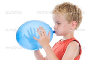 Little boy is blowing up a balloon, against a white background.